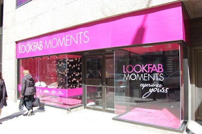 The bright pink decor extends to the studio's awning, and the window display includes hanging pink flowers.
