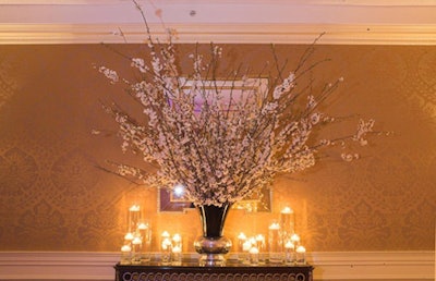 Blossom arrangements and tall glass cylinders with floating candles filled the hallway connecting the award ceremony and dinner.