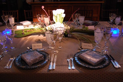 Settings combined gray linens and silver mosaic plates with white floral arrangments.