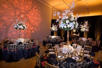 The Victorian-inspired Gallery 1 featured black bustle chair skirts, while the gobos projected on the wall matched the table-linen pattern. The room's black velvet curtains were placed along the wall at the last minute when curators removed the original display of photographs, due to a request from the owners, D.C. collectors Norman Carr and Carolyn Kinder Carr.