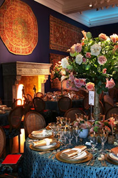 Covered in tapestries and lit by a fabric faux fire, the Mantle Room featured cane-back chairs, blue quilted silk linens, and three-foot-tall rose and calla lily centerpieces.