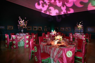 Gallery 30 brightened the room's usual dark color scheme with green and coral plaid linens, matching chair covers (with hand-stitched blossom shapes down the back), and arrangements of orange tulips, sweetpeas, and cherry blossoms.