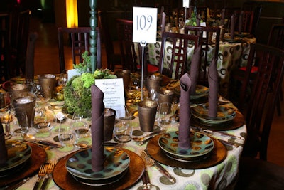 Gallery 29's tables featured standing twisted brown napkins, accented by stemless glasses, gold-leaf-encrusted water tumblers, and green orchid arrangements with moss bases.