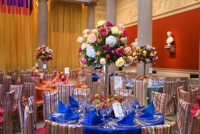 The colorful pinstriped chair covers from Perfect Settings inspired the atrium's design scheme, accented by four-foot-tall arrangements of roses and hydrangea.