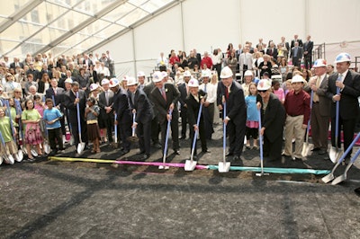 Dignitaries donned hard hats and dug into troughs of dirt under the tent's floorboards.