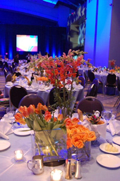 Powder blue and orange were the night's colors, with centerpieces featuring orange snapdragons, tulips, and roses in staggered square glass vases.
