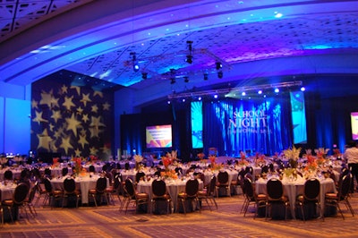 The Fight for Children School Night dinner glowed with deep-blue lighting and star-shaped projections.