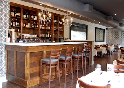 Two simple silver chandeliers hang over the oak bar, which seats four.