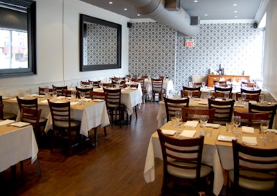 The back section of the restaurant features two large mirrors and an antique table set against the far wall.