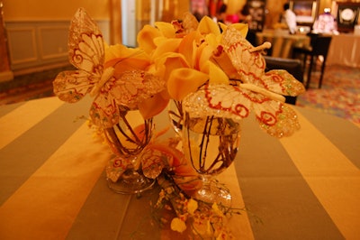 Small glasses filled with orchids and butterfly ornaments topped cocktail tables in the silent-auction room.