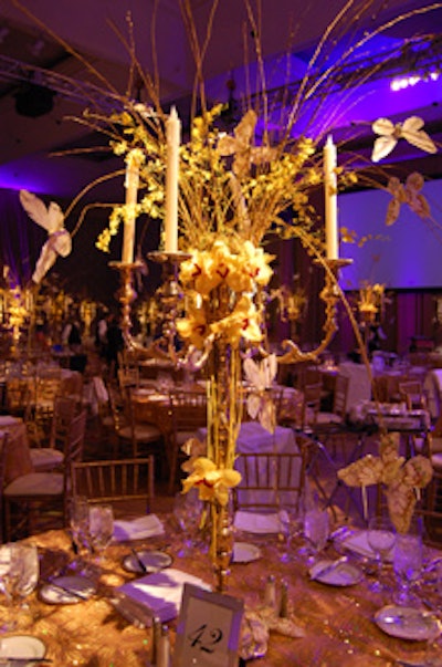 Tall gold candelabras, adorned with orchids and butterfly decorations, topped tables in the dining room.
