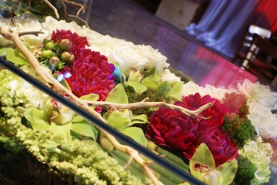 Clear acrylic cocktail tables were filled with green orchids, white roses, and an assortment of tropical florals.