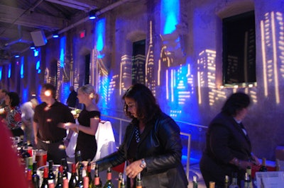 Blue spotlights illuminated the projections of buildings behind the tables where wineries, breweries, and restaurants served guests.