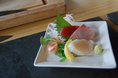 A sashimi bar offered plates of raw hamachi, tuna, and Japanese scallop on wakame salad, with two choices of sauce.