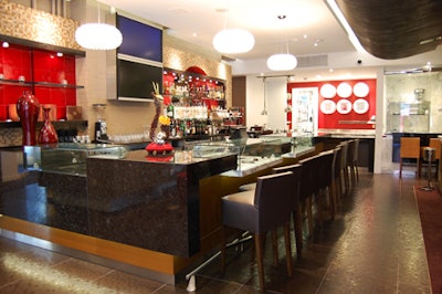 The bar is covered in Italian gray granite, with a flat-screen TV that will project video of the glass-enclosed chef's preparation area (pictured, to the right).