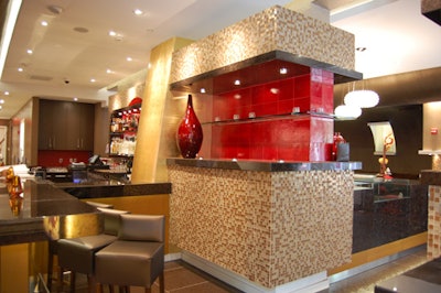 The two-sided bar that separates the space features brown and red tiling and stool seating.