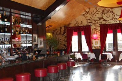 A green granite-topped bar, red leather barstools, and stocked glass shelves make up Park 52's lounge.