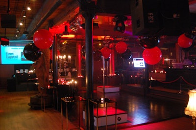 Large black and red balloons hung from the ceiling of the red-lit club.