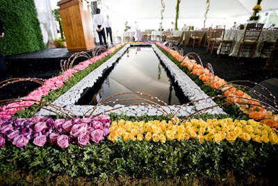 A miniature reflecting pool, edged with roses and stones, sat in front of the event's lectern.