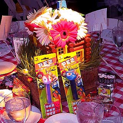 Centerpieces by Johnny Jupiter and Friends at the Fresh Air Fund's annual gala were boxes filled with grass and gerbera daisies in a mini log cabin made of Lincoln Logs. Candy and Pez dispensers donated by FAO Schwarz surrounded the displays.