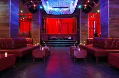 The main room of the lower level has a clublike feel, with red banquettes, programmable lighting, and wooden floors.