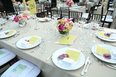 Pink floral centerpieces topped dinner tables in the outdoor setting.