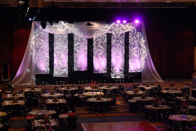 The backdrop at the end of the ballroom, from Hargrove, featured gobo projections of rosette shapes on sheer hanging fabric.