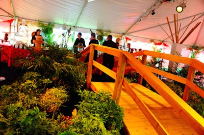 An arched wooden bridge lined with tropical plants and miniature koi ponds led guests into the space.