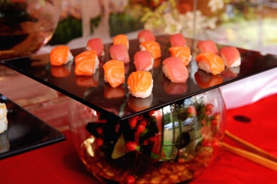 Trays of assorted sashimi were placed atop fishbowls filled with fresh flowers.