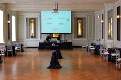 During the cocktail reception, video screens projected the event underwriters' logos, while tables topped with navy and gray linens held simple floral centerpieces.