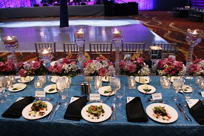 Teal linens and rose-filled, mirrored boxes decorated dinner tables.