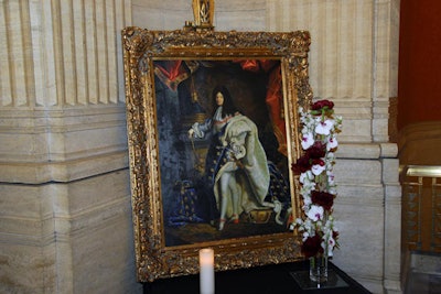 A silent auction featured French-themed items, including a painting of Louis XIV.