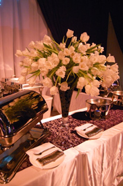Floral arrangments of white tulips topped the food stations and bars throughout the main event space.