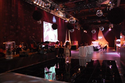 Disco balls and large black feather balls hung above the black acrylic dance floor courtesy of Contemporary Furniture Rentals.