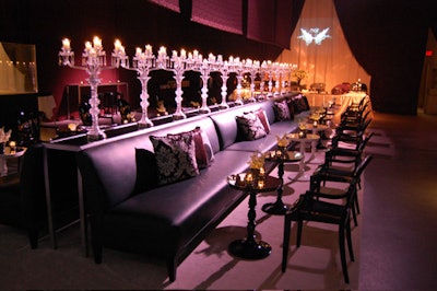 Tall glass tables topped with clear glass candelabras sat between two rows of black leather seating in the main space.