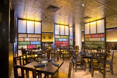 The main dining space, with a pressed-copper roof and wood seating, is divided by curtained glass panels.