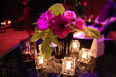 Black PVC fabric dressed cocktail tables topped with loose Swarovski crystals, tea-light candles, and black vases filled with pink flowers from San Remo Florist.