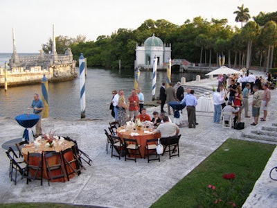 Tables topped with iridescent crushed orange and blue linens were placed alongside the bay.