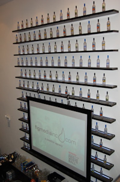 Shelves of Grey Goose and a projection screen bearing sponsors' logos hung behind a downstairs bar.