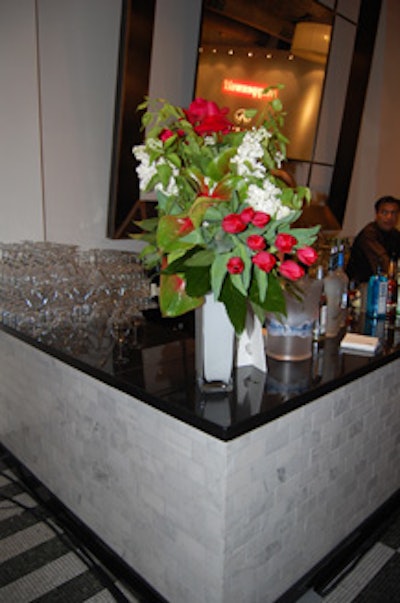 Red and white floral arrangements, which reflected the evening's color scheme, decorated the bar next to the silent auction.