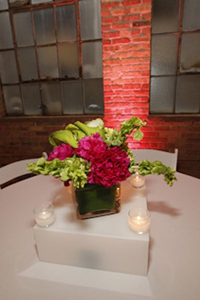 At each dinner table, flower-filled vases sat atop illuminated Lucite boxes. 'The flowers brought an elegant, lush quality to the warehouse space,' said NetJets events manager Patrick Vega.