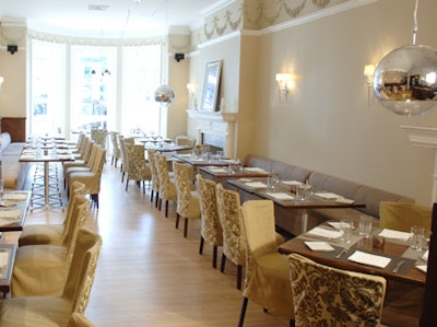 The 70-seat dining room is awash in neutral tones, with canvas chair covers and beige suede benches.