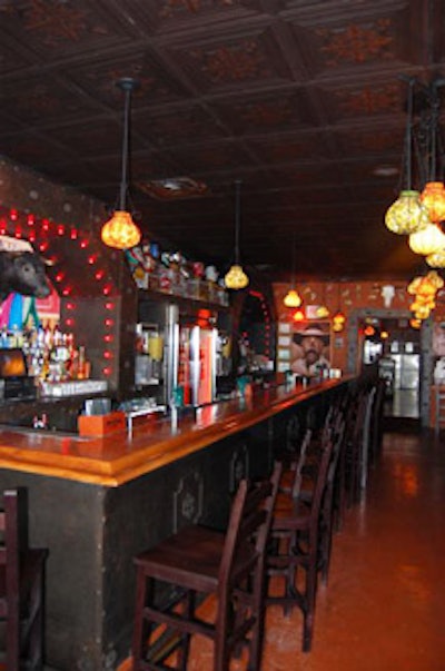 A bar sided with custom ironwork and topped with tiles dominates the front room on the first level.