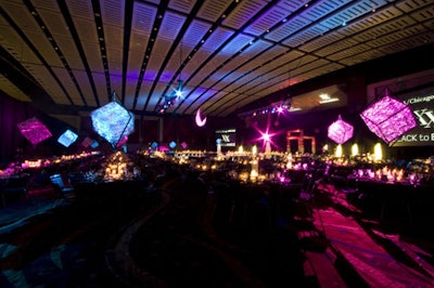 Nearly a dozen 10-foot-tall light-reflecting cubes positioned on metal structures decorated dining tables.