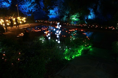 French lighting designer Julien Pavillard added different types of flower-shaped lighting elements to the garden, including colorful glass votives.