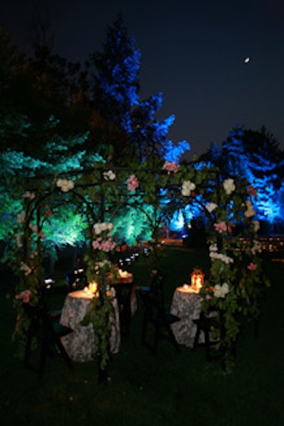 A metal gazebo strewn with roses offered additional seating and tables adorned in black and white toile linens.