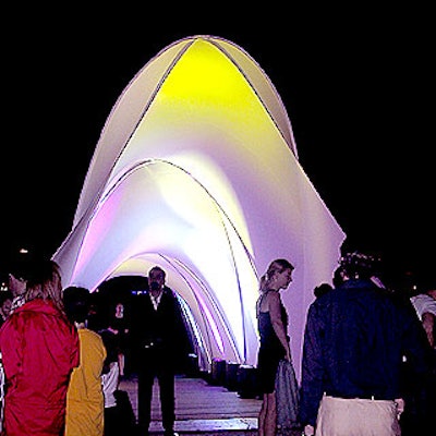 Lighting from Total Entertainment lit up the fabric sculpture tunnel from Pink Inc. at the entrance to the party.