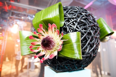 Floral arrangements featuring twigs wrapped into spheres topped the bars throughout the venue.