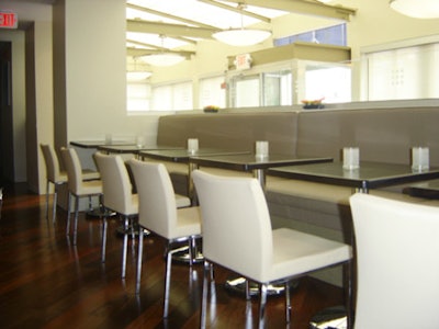 The 62-seat dining room pairs beige leather booths with white chairs with Brazilian walnut floors.