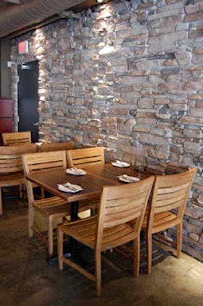 A back wall is covered in natural stone and illuminated by pot lights.